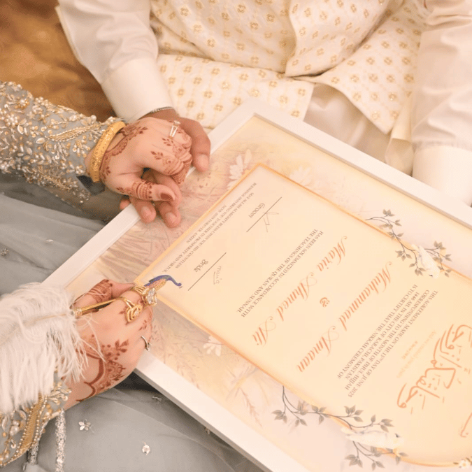Bride and Groom Signing a Nikkah Nama by The Framers