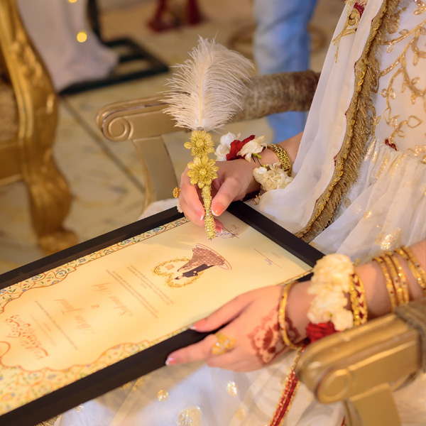 Girl Signing a Nikkah Certificate by The Framers
